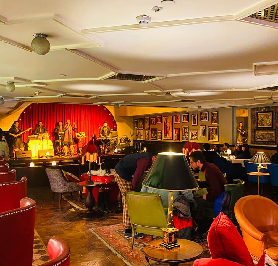 A lively room with a stage and bar, filled with people enjoying the entertainment and company